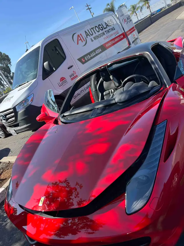 The branded A1 Auto Glass mobile service van parked on a job beside a red Ferrari
