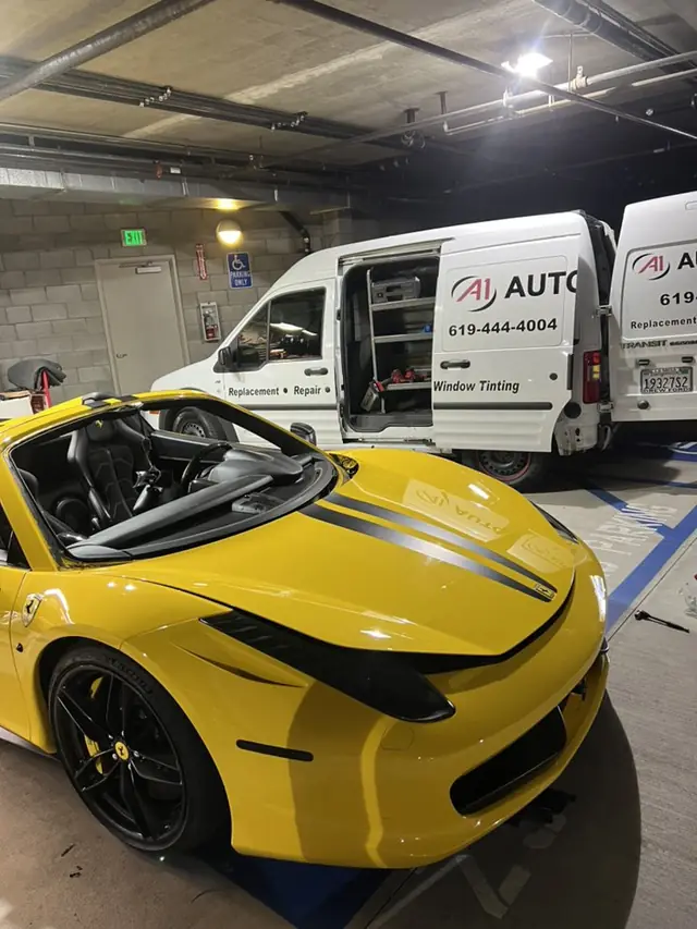 The A1 Auto Glass mobile van's tool rack set up for a parking garage job with a yellow Ferrari parked alongside
