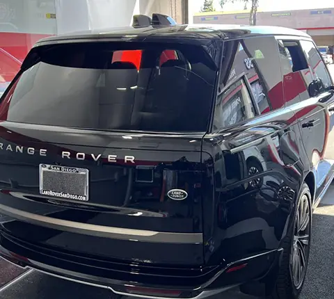 A black Range Rover freshly tinted with the A1 Auto Glass shop color scheme visible behind it