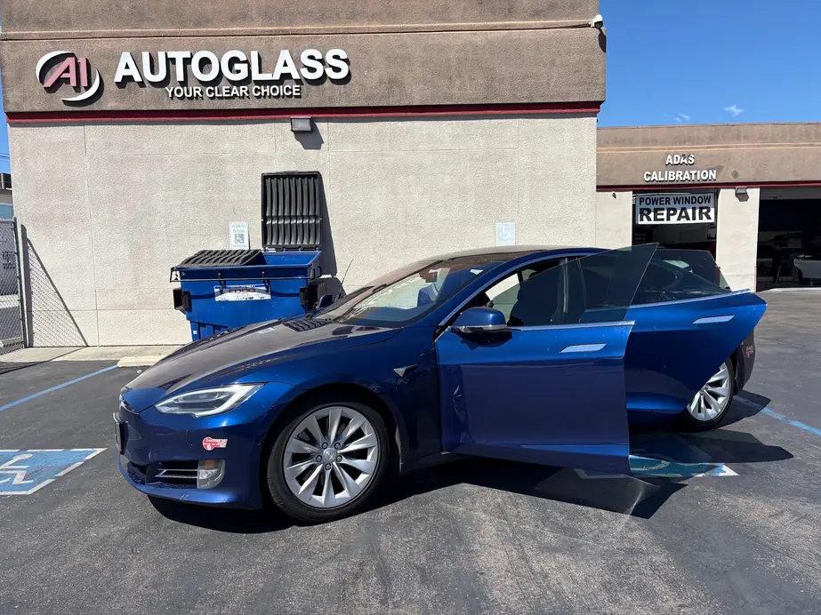 The A1 Auto Glass storefront under ADAS Calibration signage, a Tesla Model S mid service in the bay